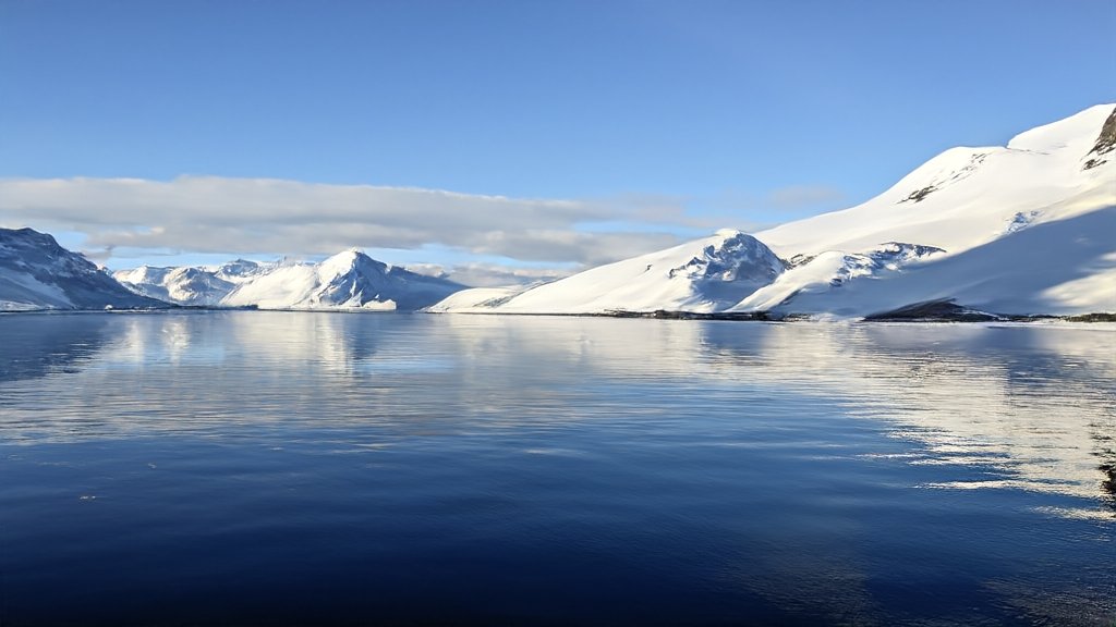 Panoramic view of the Arctic landscape with icy waters under a bright sky, alongside a serene image of the Norwegian Sea, emphasising the pristine environments protected by new emission control areas.